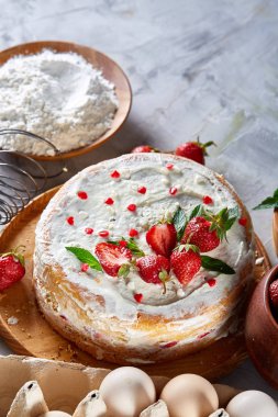 Çilekli tart beyaz arka plan üzerinde düz yatıyordu organik maddeler tarafından çevrili ekşi krem şanti ile kaplı.