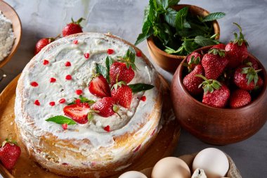 Çilekli tart beyaz arka plan üzerinde düz yatıyordu organik maddeler tarafından çevrili ekşi krem şanti ile kaplı.