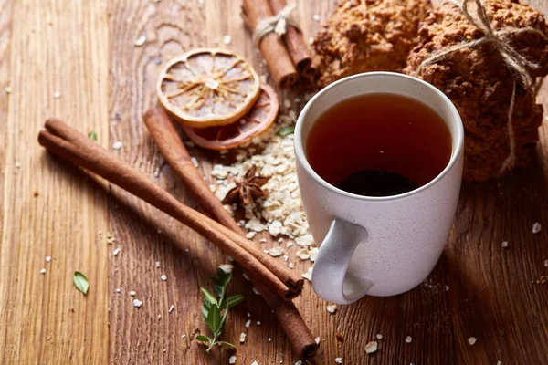 Bir fincan sıcak çay, kurabiye ve dekorasyon ahşap arka plan, seçici odak üzerinde bir oturum ile Noel kavramı
