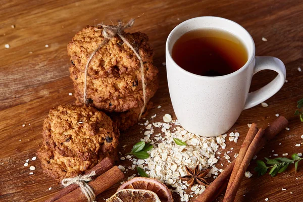 Bir fincan sıcak çay, kurabiye ve dekorasyon ahşap arka plan, seçici odak üzerinde bir oturum ile Noel kavramı