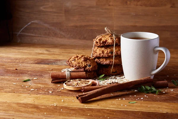 Bir fincan sıcak çay, kurabiye ve dekorasyon ahşap arka plan, seçici odak üzerinde bir oturum ile Noel kavramı