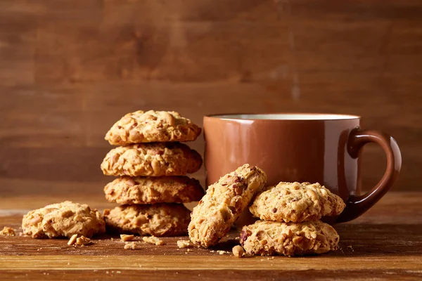 Porcelain cup of tea and sweet cookies on wooden background, top view, selective focus — Stock Photo, Image