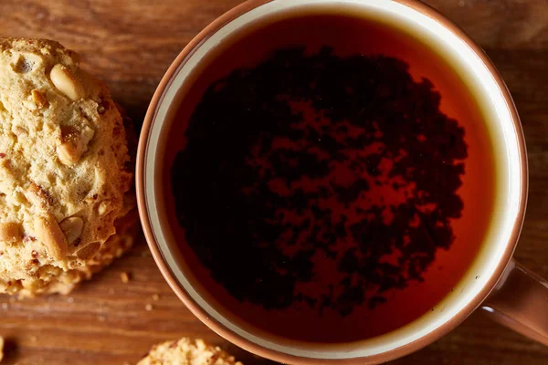 Porselen fincan çay ve tatlı kurabiye ahşap arka plan, üstten görünüm, seçici odak