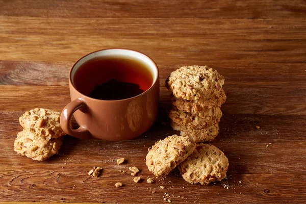 Porselen fincan çay ve tatlı kurabiye ahşap arka plan, üstten görünüm, seçici odak