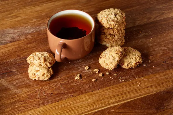 Xícara de porcelana de chá e biscoitos doces em fundo de madeira, vista superior, foco seletivo — Fotografia de Stock