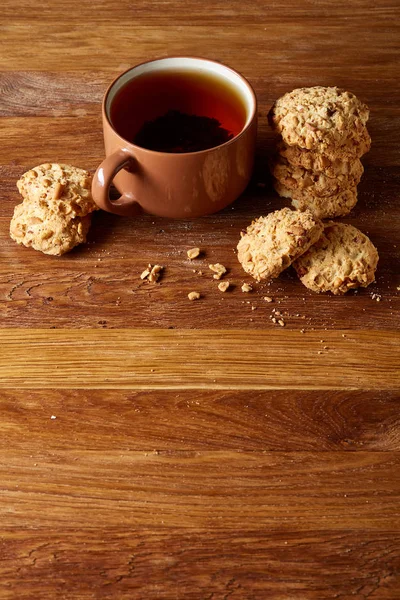 Porselen fincan çay ve tatlı kurabiye ahşap arka plan, üstten görünüm, seçici odak