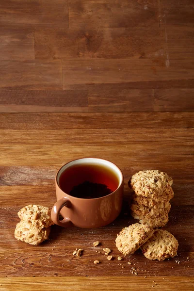 Porselen fincan çay ve tatlı kurabiye ahşap arka plan, üstten görünüm, seçici odak