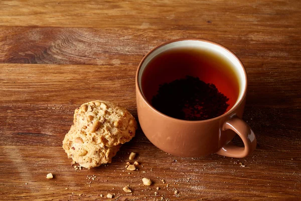 Porselen fincan çay ve tatlı kurabiye ahşap arka plan, üstten görünüm, seçici odak