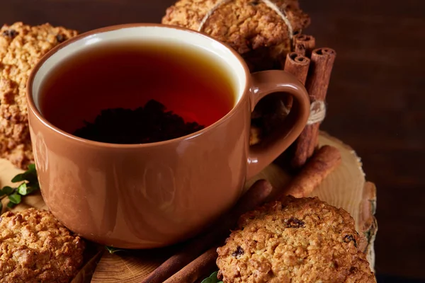 Bir fincan sıcak çay, kurabiye ve dekorasyon ahşap arka plan, seçici odak üzerinde bir oturum ile Noel kavramı