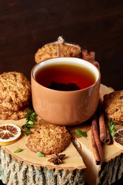Bir fincan sıcak çay, kurabiye ve dekorasyon ahşap arka plan, seçici odak üzerinde bir oturum ile Noel kavramı