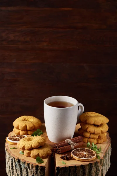 Bir fincan sıcak çay, kurabiye ve dekorasyon ahşap arka plan, seçici odak üzerinde bir oturum ile Noel kavramı