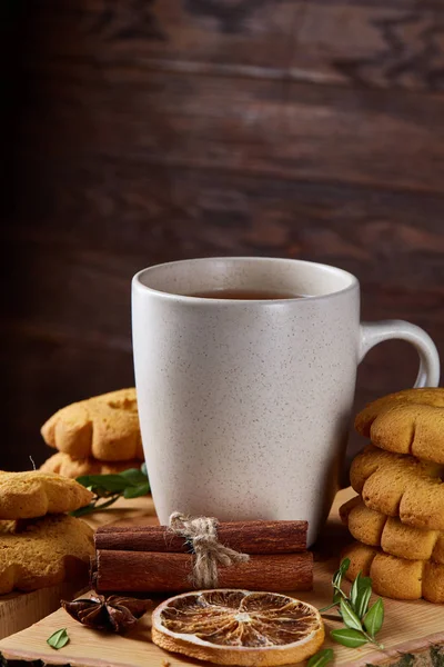Bir fincan sıcak çay, kurabiye ve dekorasyon ahşap arka plan, seçici odak üzerinde bir oturum ile Noel kavramı