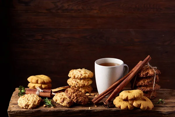 Kavramsal şenlikli bileşimi ile bir fincan sıcak çay, kurabiye ve spicies bir ahşap varil, seçici odak, yakın çekim
