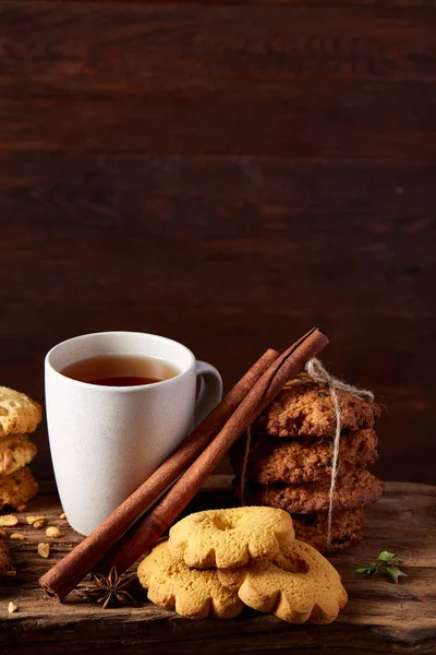 Kavramsal şenlikli bileşimi ile bir fincan sıcak çay, kurabiye ve spicies bir ahşap varil, seçici odak, yakın çekim