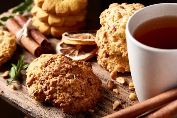 Kavramsal şenlikli bileşimi ile bir fincan sıcak çay, kurabiye ve spicies bir ahşap varil, seçici odak, yakın çekim