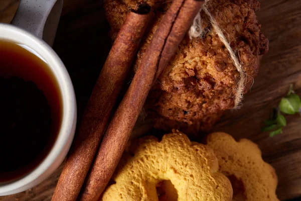 Kavramsal şenlikli bileşimi ile bir fincan sıcak çay, kurabiye ve spicies bir ahşap varil, seçici odak, yakın çekim