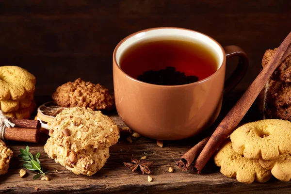 Kavramsal şenlikli bileşimi ile bir fincan sıcak çay, kurabiye ve spicies bir ahşap varil, seçici odak, yakın çekim