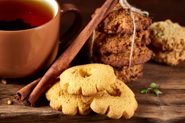 Kavramsal şenlikli bileşimi ile bir fincan sıcak çay, kurabiye ve spicies bir ahşap varil, seçici odak, yakın çekim