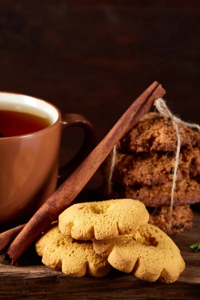 Composição festiva conceitual com uma xícara de chá quente, biscoitos e espiões em um barril de madeira, foco seletivo, close-up — Fotografia de Stock