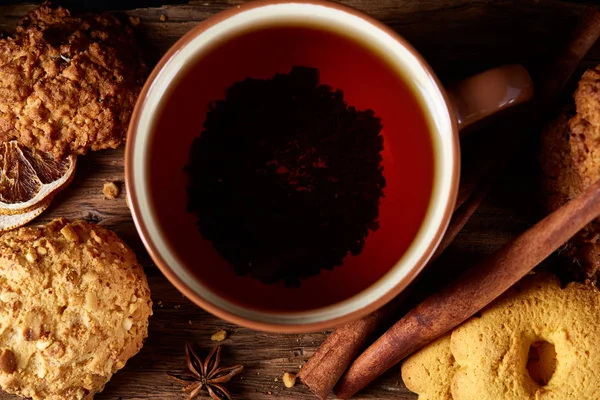 Kavramsal şenlikli bileşimi ile bir fincan sıcak çay, kurabiye ve spicies bir ahşap varil, seçici odak, yakın çekim