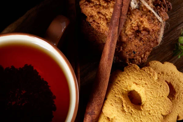 Kavramsal şenlikli bileşimi ile bir fincan sıcak çay, kurabiye ve spicies bir ahşap varil, seçici odak, yakın çekim