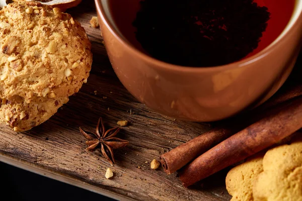 Kavramsal şenlikli bileşimi ile bir fincan sıcak çay, kurabiye ve spicies bir ahşap varil, seçici odak, yakın çekim