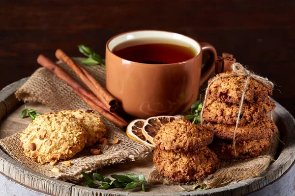 Kavramsal şenlikli bileşimi ile bir fincan sıcak çay, kurabiye ve spicies bir ahşap varil, seçici odak, yakın çekim