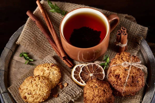 Kavramsal şenlikli bileşimi ile bir fincan sıcak çay, kurabiye ve spicies bir ahşap varil, seçici odak, yakın çekim