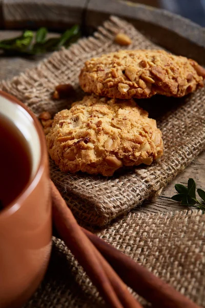 Kavramsal şenlikli bileşimi ile bir fincan sıcak çay, kurabiye ve spicies bir ahşap varil, seçici odak, yakın çekim