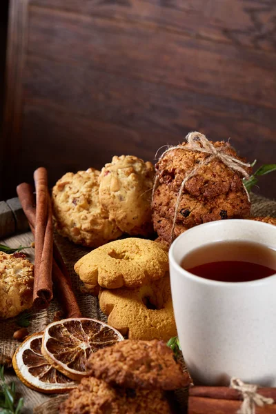 Kavramsal şenlikli bileşimi ile bir fincan sıcak çay, kurabiye ve spicies bir ahşap varil, seçici odak, yakın çekim
