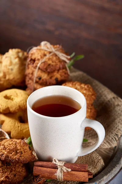 Composición festiva conceptual con una taza de té caliente, galletas y espigas en un barril de madera, enfoque selectivo, primer plano — Foto de Stock