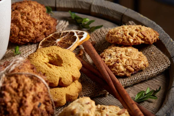 Kavramsal şenlikli bileşimi ile bir fincan sıcak çay, kurabiye ve spicies bir ahşap varil, seçici odak, yakın çekim