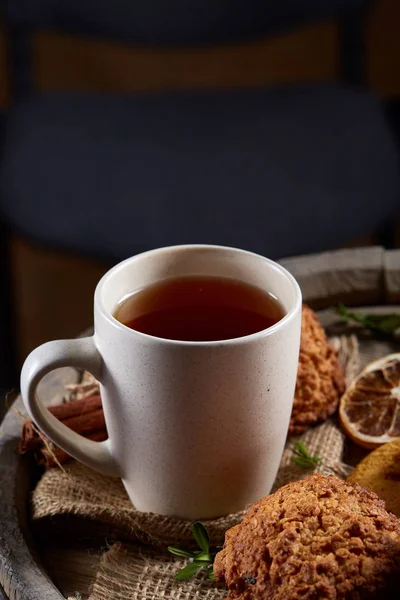 Kavramsal şenlikli bileşimi ile bir fincan sıcak çay, kurabiye ve spicies bir ahşap varil, seçici odak, yakın çekim