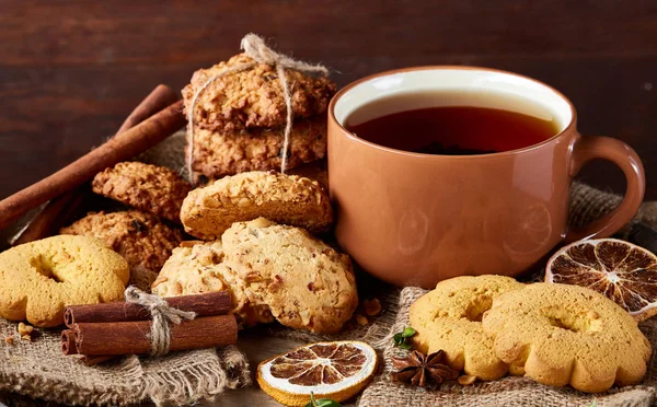 Bir fincan sıcak çay, kurabiye ve dekorasyon ahşap arka plan, seçici odak üzerinde bir oturum ile Noel kavramı