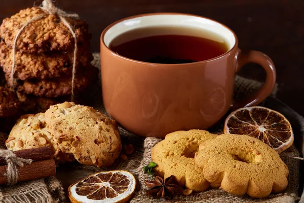 Bir fincan sıcak çay, kurabiye ve dekorasyon ahşap arka plan, seçici odak üzerinde bir oturum ile Noel kavramı