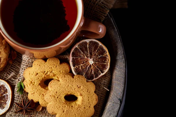 Bir fincan sıcak çay, kurabiye ve dekorasyon ahşap arka plan, seçici odak üzerinde bir oturum ile Noel kavramı