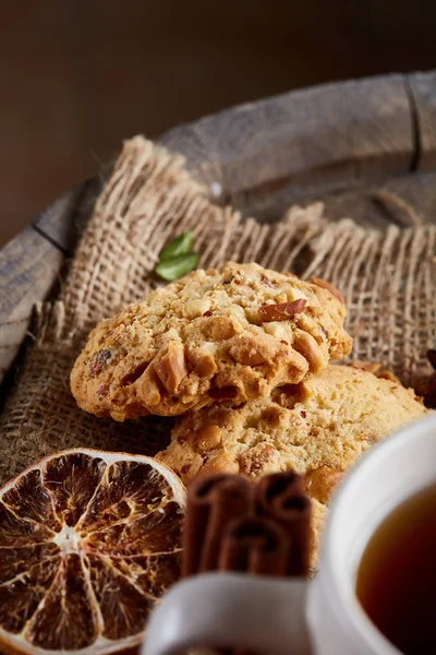 Beyaz porselen kupa çay ve tatlı kurabiye ahşap arka plan, üstten görünüm, seçici odak