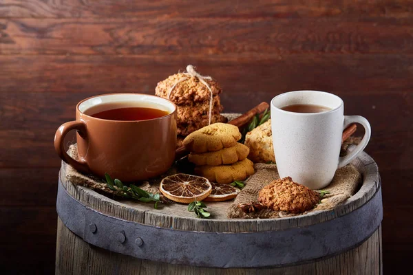 Weißer Porzellanbecher mit Tee und süßen Keksen auf Holzgrund, Draufsicht, selektiver Fokus — Stockfoto