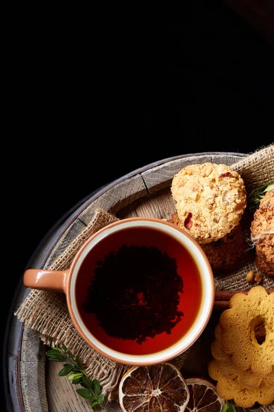 Bir fincan sıcak çay, kurabiye ve dekorasyon ahşap arka plan, seçici odak üzerinde bir oturum ile Noel kavramı