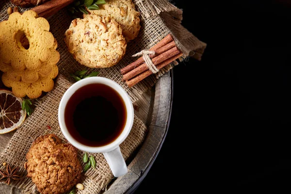 Beyaz porselen kupa çay ve tatlı kurabiye ahşap arka plan, üstten görünüm, seçici odak