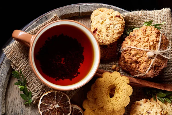 Bir fincan sıcak çay, kurabiye ve dekorasyon ahşap arka plan, seçici odak üzerinde bir oturum ile Noel kavramı