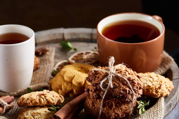 Bir fincan sıcak çay, kurabiye ve dekorasyon ahşap arka plan, seçici odak üzerinde bir oturum ile Noel kavramı