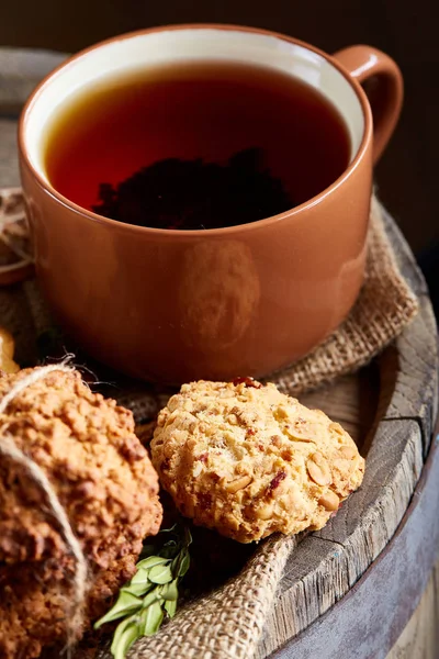 Bir fincan sıcak çay, kurabiye ve dekorasyon ahşap arka plan, seçici odak üzerinde bir oturum ile Noel kavramı