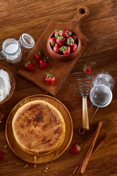Top çilekli pasta ya da kek üzerine ahşap masa, düz yatıyordu yemek pişirmek için ham maddeler görüntüleyin. Fırın arka plan.