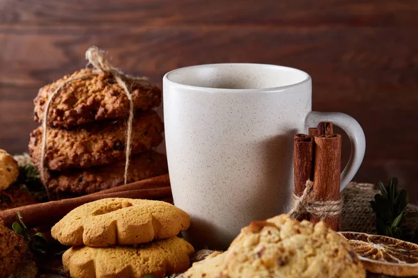 Beyaz porselen kupa çay ve tatlı kurabiye ahşap arka plan, üstten görünüm, seçici odak