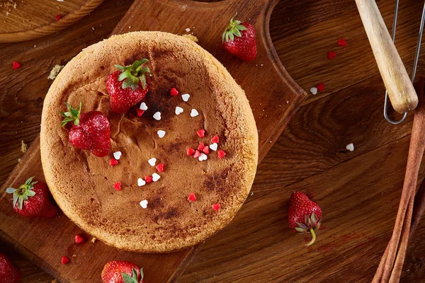 Top çilekli pasta ya da kek üzerine ahşap masa, düz yatıyordu yemek pişirmek için ham maddeler görüntüleyin. Fırın arka plan.