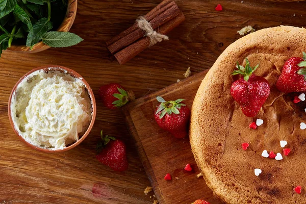 Çilekli tart ile arka plan pişirme ekşi krema ile kaplı malzemeler ahşap arka plan üzerinde.