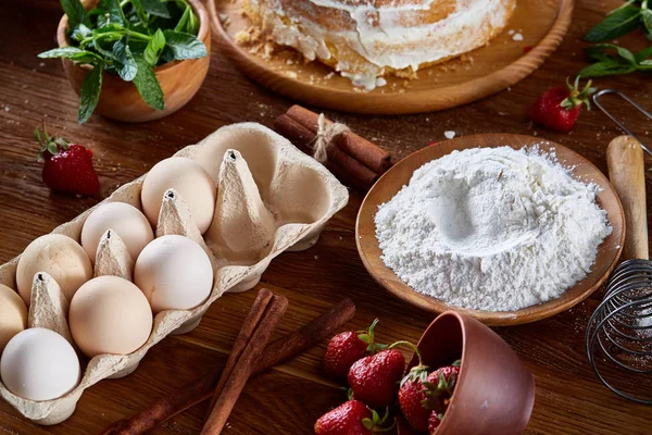 Vista superior de los ingredientes crudos para cocinar pastel de fresa o pastel en la mesa de madera, la puesta plana. Fondo de panadería . —  Fotos de Stock
