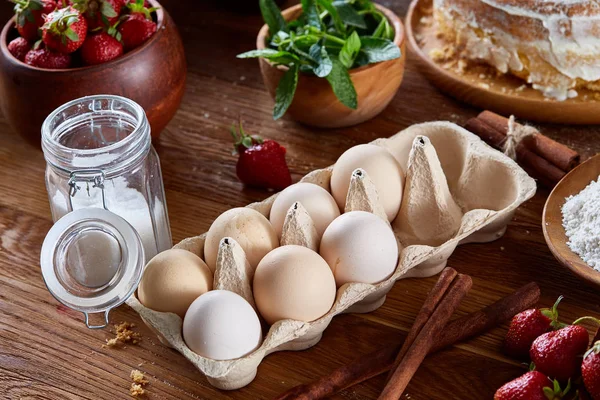 Top çilekli pasta ya da kek üzerine ahşap masa, düz yatıyordu yemek pişirmek için ham maddeler görüntüleyin. Fırın arka plan.