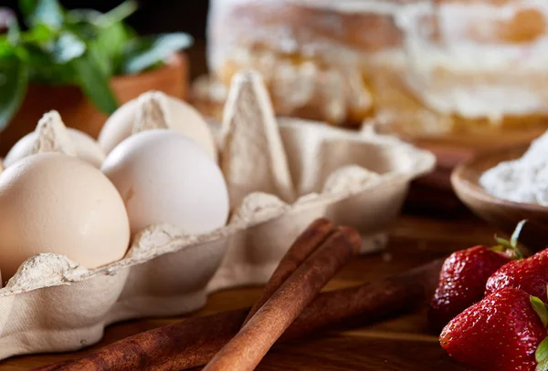 Top çilekli pasta ya da kek üzerine ahşap masa, düz yatıyordu yemek pişirmek için ham maddeler görüntüleyin. Fırın arka plan.